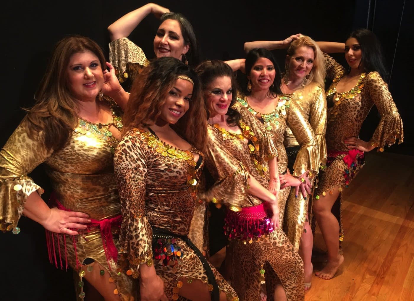 Dancers in gold costumes posing together